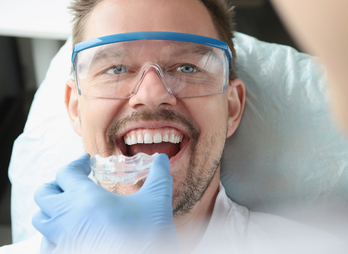Man in dental chair being fitted with mouth guard